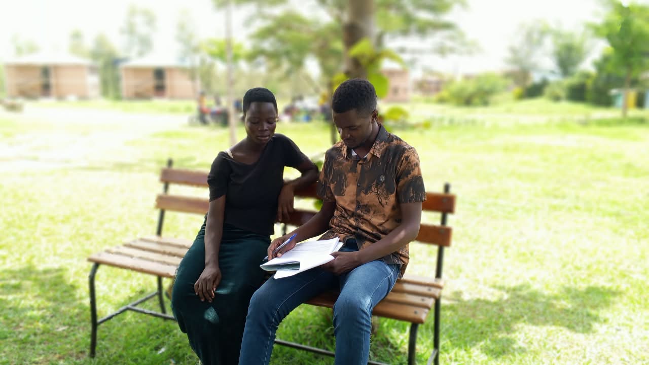 Young parents sitting together reviewing health information, Mella Uganda